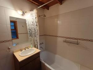 a bathroom with a sink and a bath tub at Casa Sueño in San Martín de los Andes +10 photos