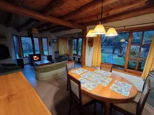 a dining room with a table and a living room at Casa Sueño in San Martín de los Andes