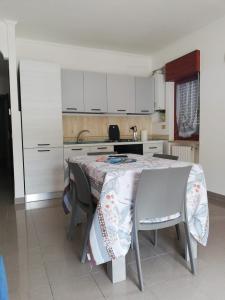 a kitchen with a table with chairs and white cabinets at Stella marina in Mattinata