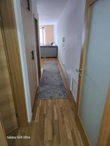 a hallway with a door and a rug on the floor at AiM apartman Bjelasnica in Bjelašnica