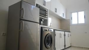 a kitchen with a refrigerator and a washer and dryer at Tamraght Waves Retreat in Tamraght Ouzdar