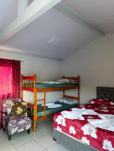 a bedroom with two bunk beds and a chair at Cantinho da Isa in Pomerode