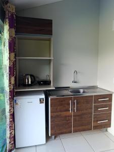 a small kitchen with a refrigerator and a sink at Cantinho da Isa in Pomerode