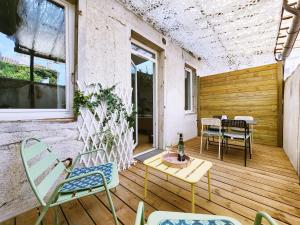 a patio with chairs and a table on a wooden floor at Polka - RDC - Centre ville - Terrasse in Auch