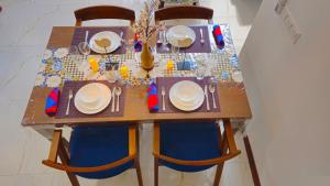 a wooden table with chairs and plates on it at Samara Villa by Trillium Residencies in Nugegoda