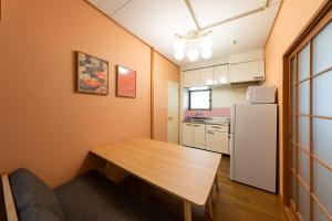 a small kitchen with a table and a refrigerator at Matsubara Station 2 minutes Shinjuku, Shibuya 15 minutes Pure Japanese style house where you can feel the seasons Maximum 6 people rent a house Quiet house in Tokyo