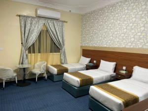 a hotel room with two beds and a table at فندق حمودة الماسي in Al Madinah