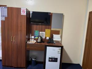 a room with a desk with a phone and a tv at فندق حمودة الماسي in Al Madinah
