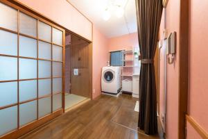 a laundry room with a washing machine in a room at Matsubara Station 2 minutes Shinjuku, Shibuya 15 minutes Pure Japanese style house where you can feel the seasons Maximum 6 people rent a house Quiet house in Tokyo