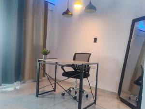 a glass desk with a chair in a room at Habitación King con baño privado, AC, cerca a centro de eventos, aeropuerto,zona bancaria y comercial in Yumbo