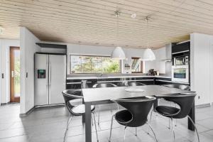 a kitchen with a table and chairs in a kitchen at FAN032-Fano-Skovly-4 in Fanø