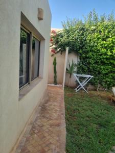 ein Gehweg neben einem Haus mit einer Pflanze in der Unterkunft Villa Marrakech réservée aux familles in Marrakesch