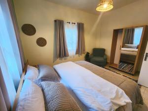 una camera da letto con un letto, una sedia e una finestra di Kadisha River House a Bcharré