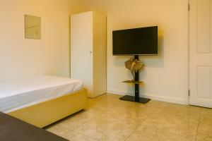 a bedroom with a bed and a flat screen tv at Countryside Retreat in Codicote
