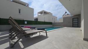 カシュテラにあるLuxury Villa Teo with heated swimming pool and panoramic viewの裏庭のプールとベンチ