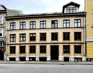 ein großes Backsteingebäude an einer Straßenseite in der Unterkunft GreenBrook Homes in Aalborg