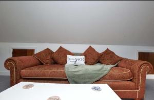 a living room with a brown couch with pillows at The Penthouse in Norwich