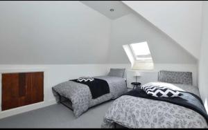 a bedroom with two beds and a window at The Penthouse in Norwich
