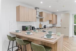 eine Küche mit einer großen Holzinsel mit grünen Stühlen in der Unterkunft 2 Bed Apartment Near City Centre - on street parking in Birmingham