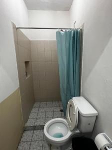 a bathroom with a toilet with a blue shower curtain at Casa Camino Real, Habitación 1, Baño privado, Cafetera Escritorio in Ciudad Valles