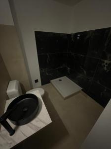 a bathroom with a black toilet and a sink at Aparthotel New Palmarium in Amélie-les-Bains-Palalda +13 photos