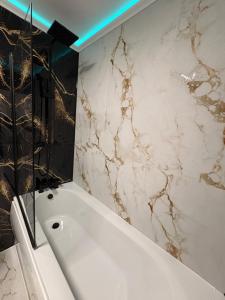 a bathroom with a white tub and a marble wall at Modern En-Suite Double Bedroom in Cardiff with Private Entrance in Cardiff +17 photos