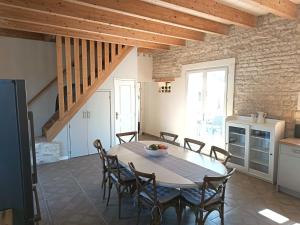 una cucina e una sala da pranzo con tavolo e sedie di Charming countryside retreat a Macqueville