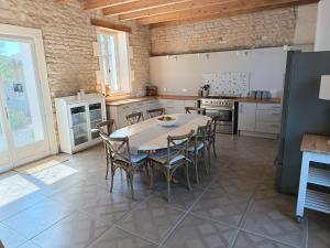 una cucina con un tavolo e sedie in una stanza di Charming countryside retreat a Macqueville