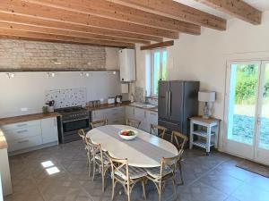 una cucina con tavolo e sedie in una cucina di Charming countryside retreat a Macqueville