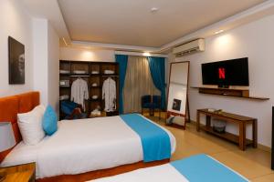 a hotel room with a bed and a tv at Pyramids Gem Plaza Hotel in Cairo