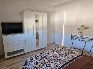 un soggiorno con TV e grande armadio bianco di Maison 3 chambres avec garage, proche de toutes commodités, quartier calme a Chalons en Champagne