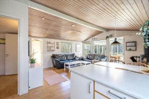 156-Ringkobing-Birkealle-14 في Nørby: مطبخ وغرفة معيشة مع أريكة وطاولة