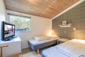 156-Ringkobing-Birkealle-14 في Nørby: غرفة نوم بها سريرين وتلفزيون بشاشة مسطحة
