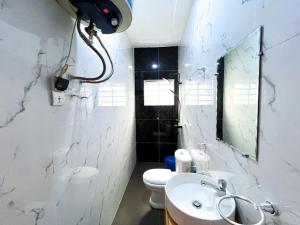 a bathroom with a toilet and a sink and a mirror at Résidences Sica in Cotonou