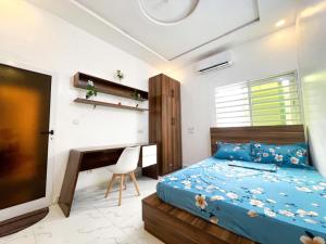 a bedroom with a bed and a desk and a television at Résidences Sica in Cotonou