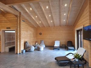 a room with wooden walls with chairs and tables at ****FH Blauvogel 60 Harz in Hasselfelde