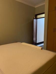 a bedroom with a bed and a door to a window at Fancy Bahai Residence- Kisaasi Bahai Road in Kampala +2 photos