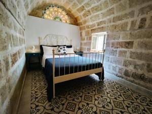a bedroom with a bed in a stone wall at Antico Gelso in Polignano a Mare