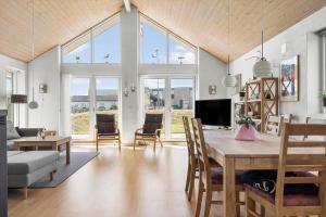 a dining room and living room with a table and chairs at 138-Ringkobing-Sondervig-Klitvej-3 in Ringkøbing