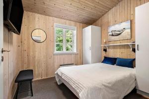 a bedroom with a bed and a window and a chair at 1093-ringkobing-Fyrrealle-3 in Ringkøbing