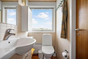 een badkamer met een wastafel en een toilet en een raam bij 1197-Ringkobing-Nordlysvej-17 in Søndervig +28 foto's
