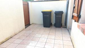 two trash cans sitting next to a building at Maison centre ville in Nogent-sur-Vernisson