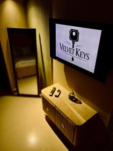 a room with a tv on a wall with a table at 1-BHK Velvet Keys Executive Suite Near Clifton Beach in Karachi