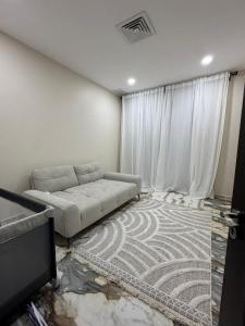 Una sala de estar con un sofá y un televisor. en Six countries apartments, en Al Khīrān