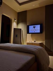 a bedroom with a bed and a tv on the wall at 1-BHK Velvet Keys Executive Suite Near Clifton Beach in Karachi