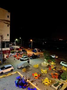 a parking lot filled with tables and cars at night at 1-BHK Velvet Keys Executive Suite Near Clifton Beach in Karachi