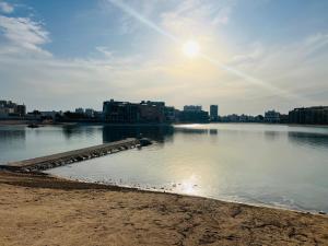 una gran masa de agua con edificios en el fondo en Six countries apartments, en Al Khīrān