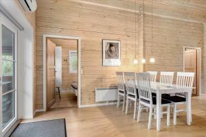 a dining room with a white table and chairs at 128-Ringkobing-Troldedalen-18 in Nørby