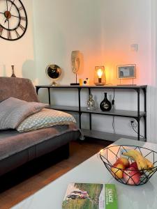ein Wohnzimmer mit einem Bett und einem Tisch mit einer Obstschale in der Unterkunft Cosy 2P - Parking - Tram - Marché de Noël à 20min in Ostwald