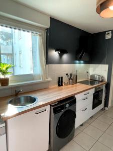 eine Küche mit Spüle und Arbeitsplatte in der Unterkunft Cosy 2P - Parking - Tram - Marché de Noël à 20min in Ostwald